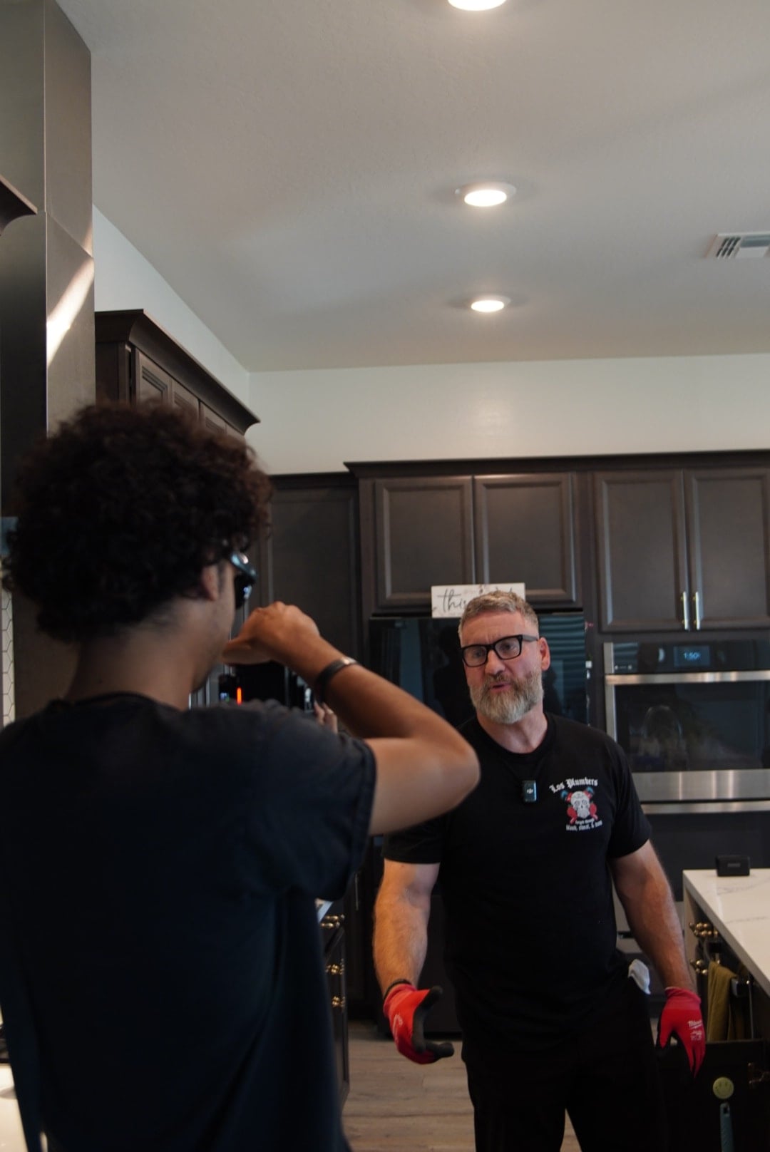 A Stray videographer documenting a plumbing professional during in-home work
